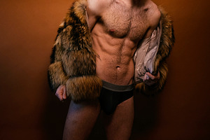 Confident man wearing fur coat and underwear in studio, a Photo by karrastock