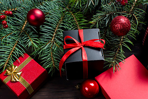 Black and red christmas gift box with red ribbon and fir bran