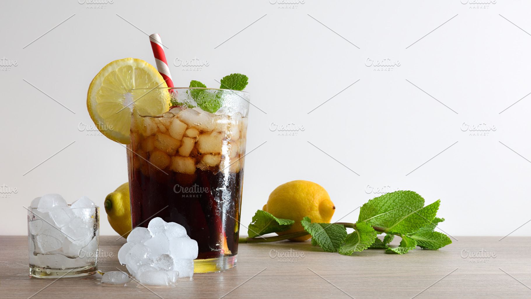 Refreshing cola drink with mint and lemon on wooden table, a Food & Drink Photo by Davizro's Market