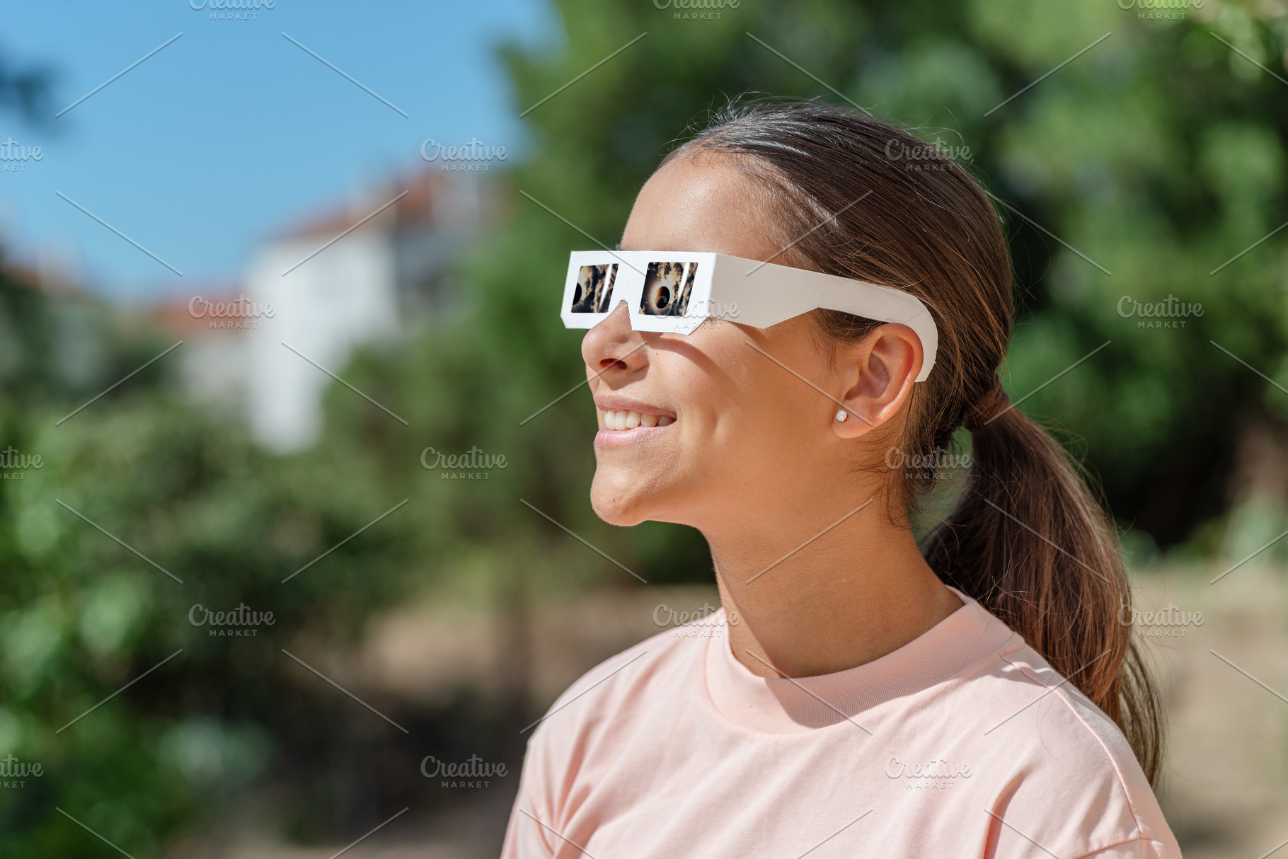 Young girl watches a solar eclipse, a School & Education Photo by Volff