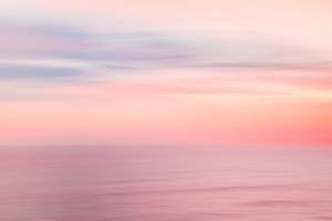 Defocused sunrise sky and ocean stock photo containing abstract and artistic