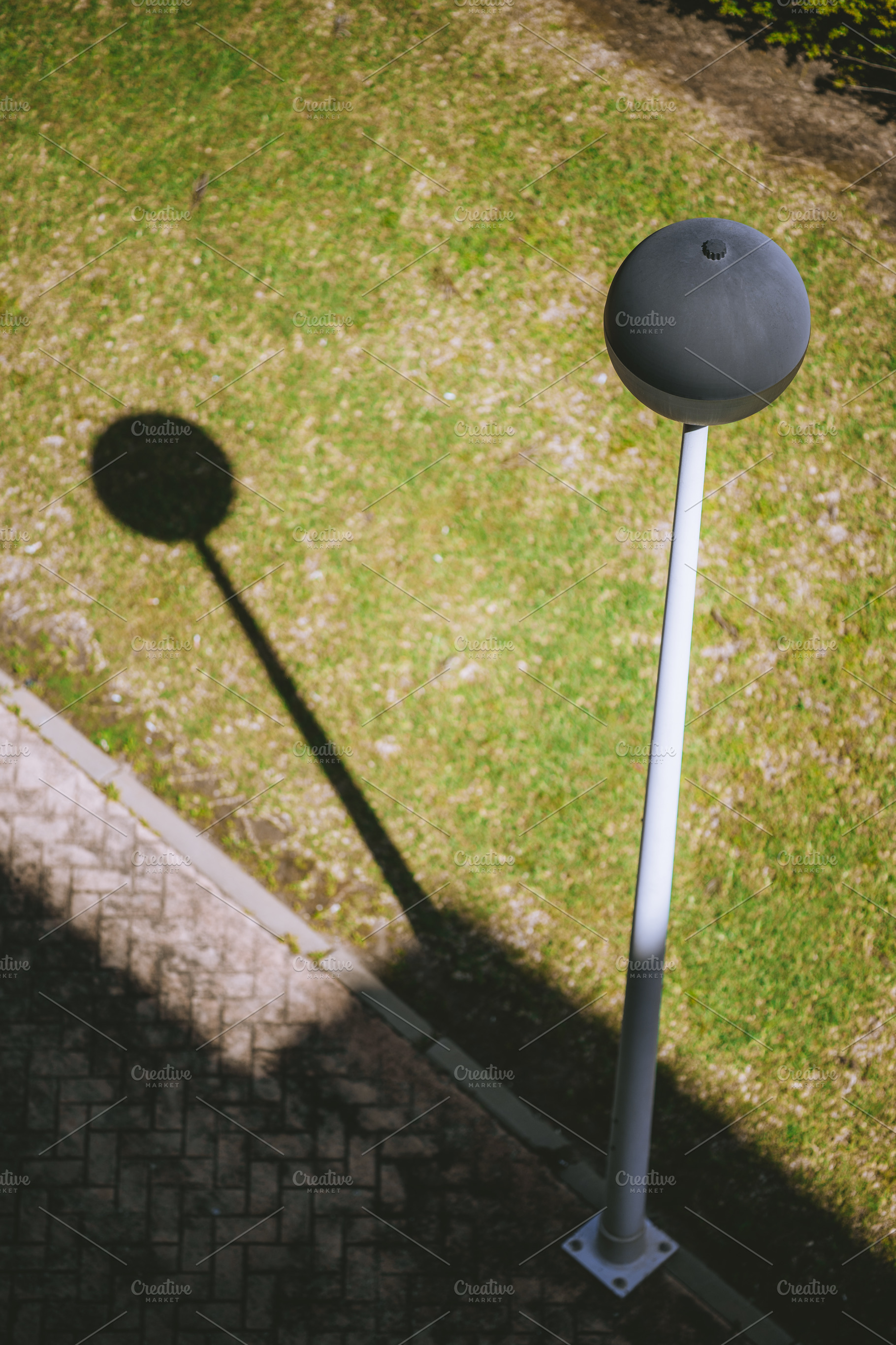 Streetlamp shadow on sunny grass, an Architecture Photo by SkyNext