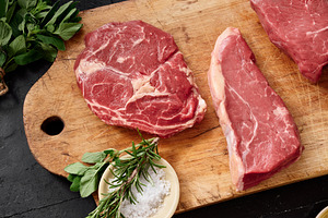 Raw rib-eye, roast beef, flank and rump steak on a wooden cutting board placed, a Food & Drink Photo by Asya Nurullina