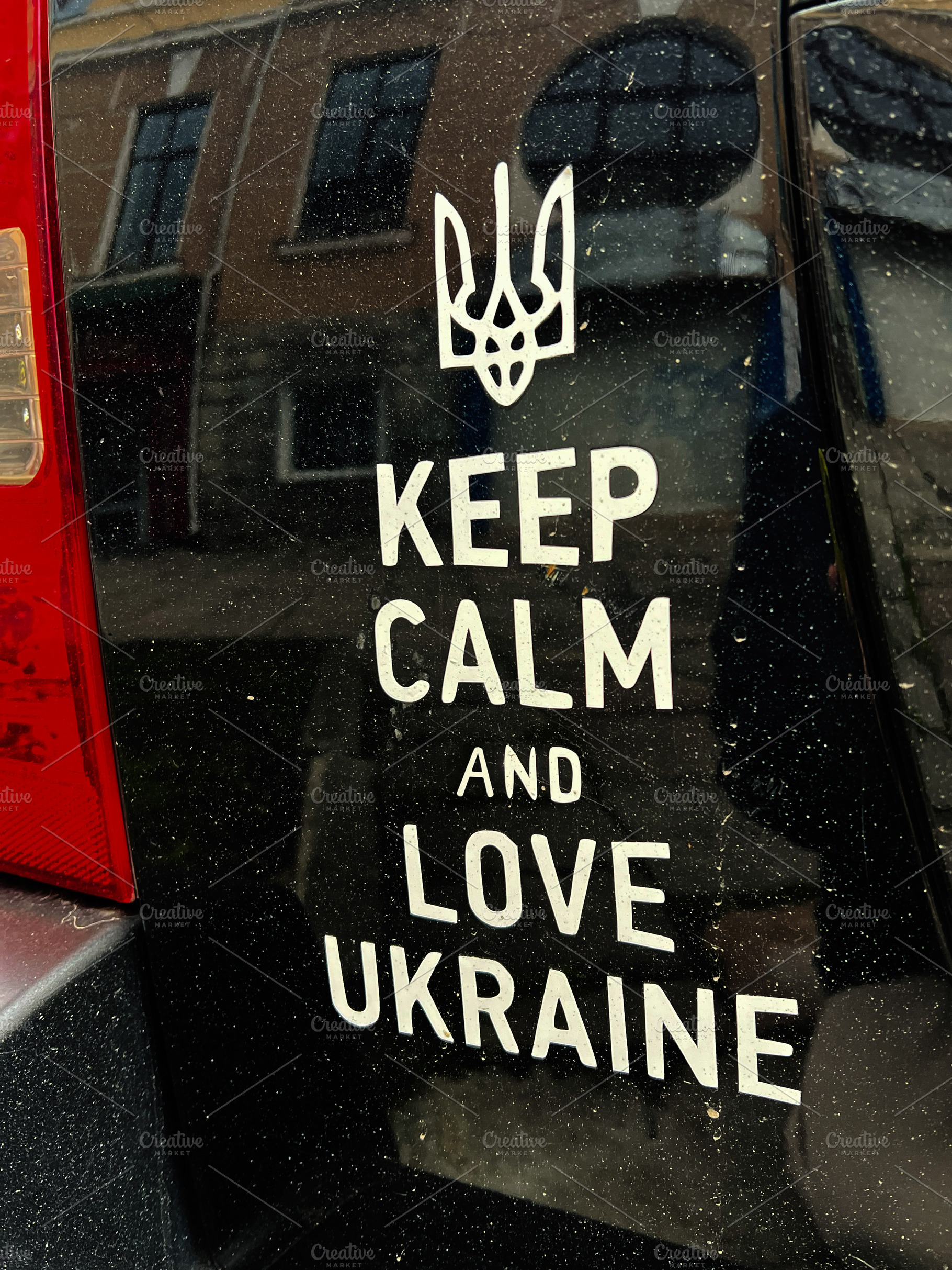 Car decal with message supporting Ukraine and its symbolic emblem. Keep calm an, a Photo by AS photostudio