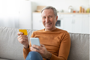Mature man using phone and credit, a Person Photo by Prostock-Studio