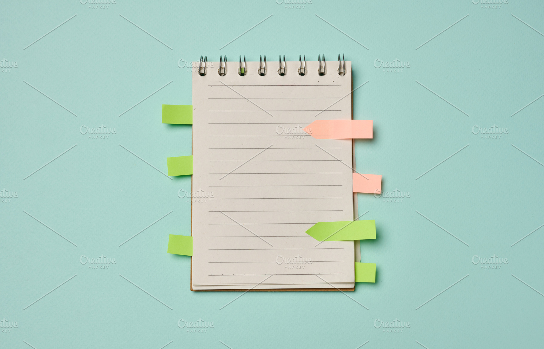 Spiral-bound lined notebook with colorful sticky index tabs on a, a Business Photo by ndanko