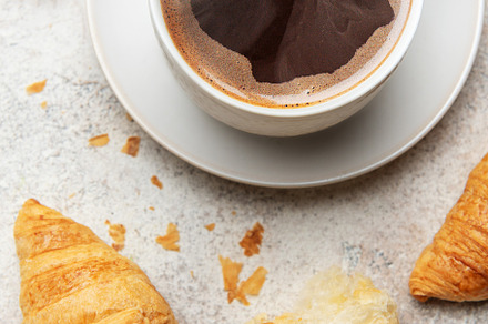 Freshly baked croissants and steaming cup of coffee creating per
