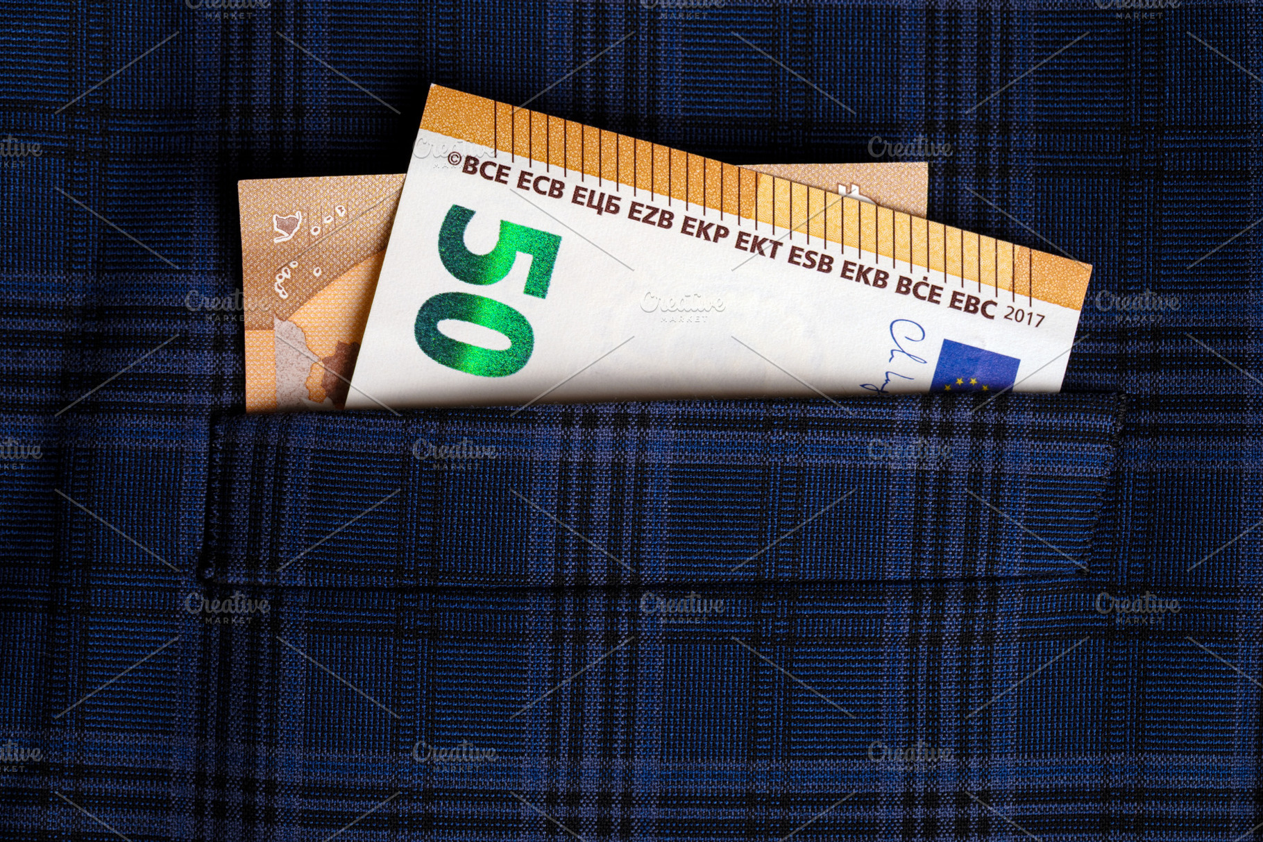 Fifty euro banknote peeking out of a blue plaid shirt pocket, symbolizing savin, a Business Photo by Ales Munt