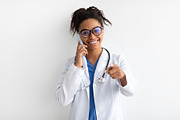 Portrait of black doctor smiling and posing to camera, a Photo by Prostock-Studio (Thumbnail 2 of 2)