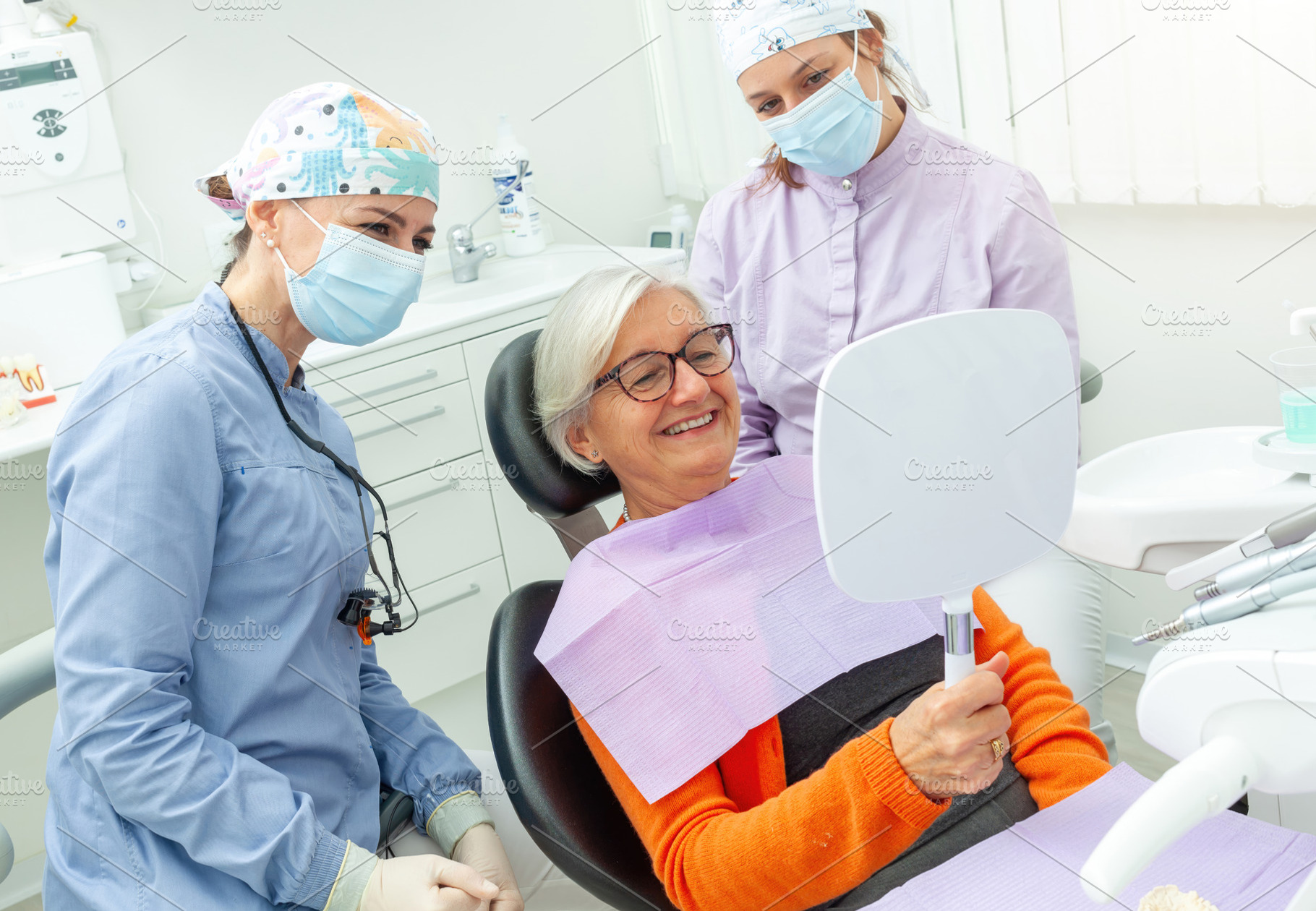 Senior woman admiring her smile after dental checkup, a Health & Medical Photo by Antonio Gravante Market