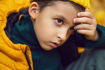 portrait of a fashionable serious child boy autumn sitting on a trail in orange, a Person Photo by SaulichPhoto
