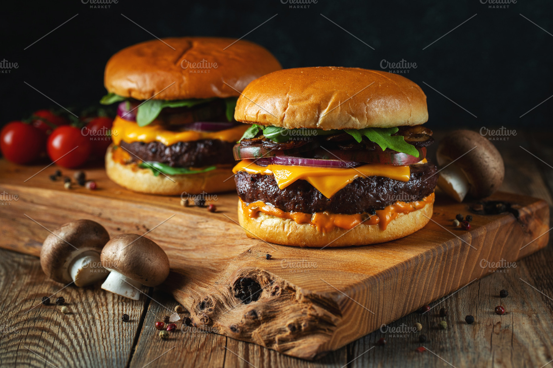 Two delicious homemade burgers of beef, cheese and mushrooms on an wooden table, a Food & Drink Photo by Budarinphoto