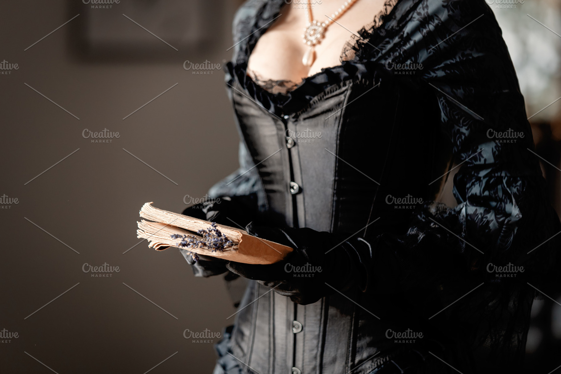 Beautiful woman in black dress holding a book and lavender flowe, a Person Photo by Masson Simon