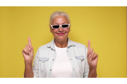 An elderly woman points her finger