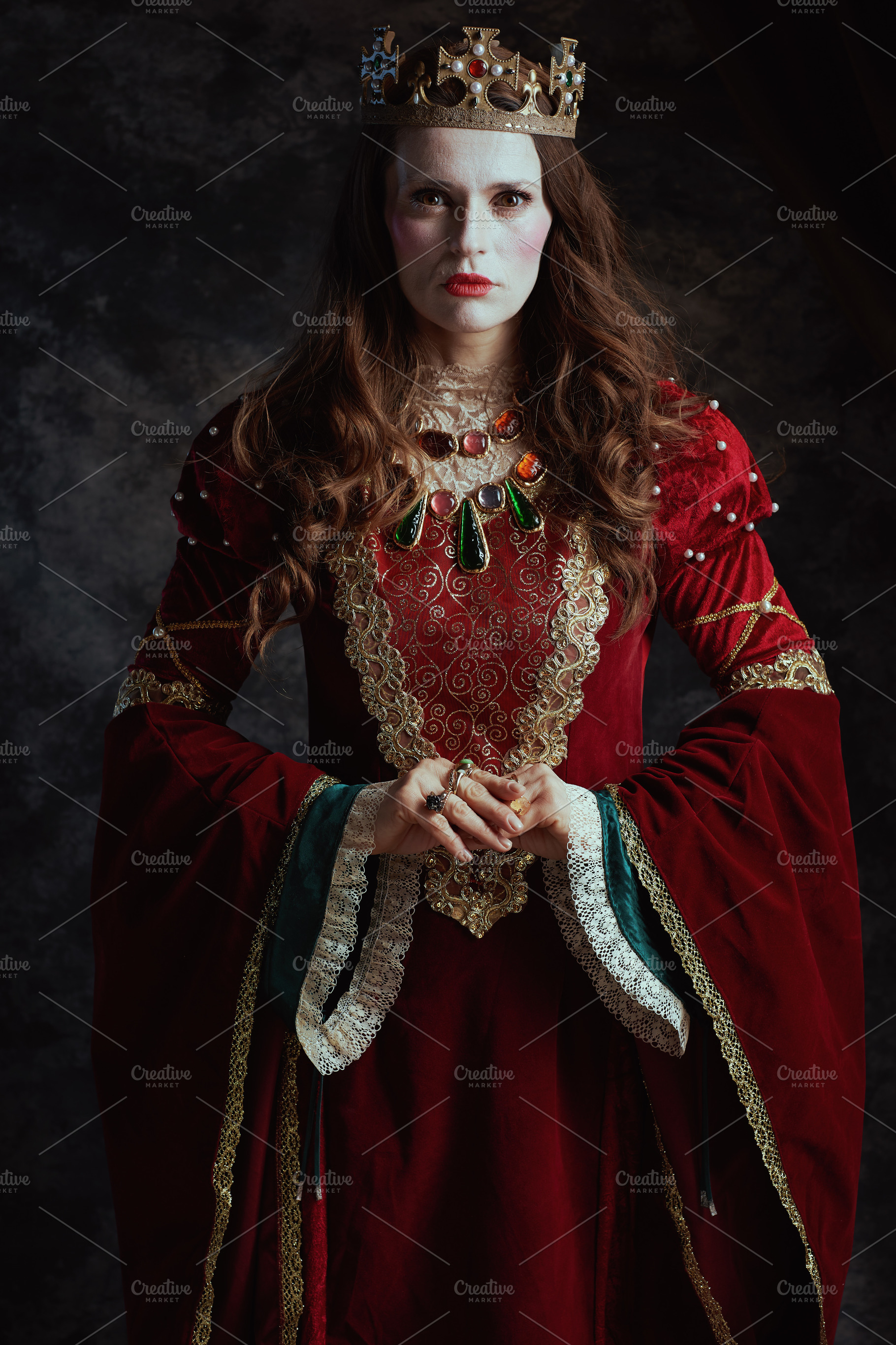 medieval queen in red dress with white makeup and crown, a Person Photo by Alliance Images