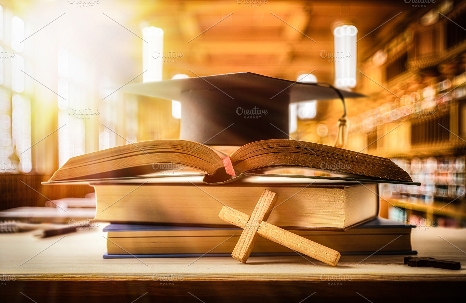 Stack of books with Bible and mortarboard in a classroom, a School & Education Photo by Davizro's Market