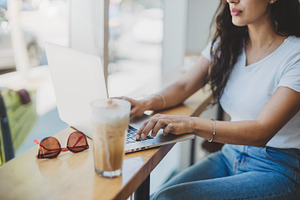 Business woman sitting in cafe containing laptop, woman, and using
