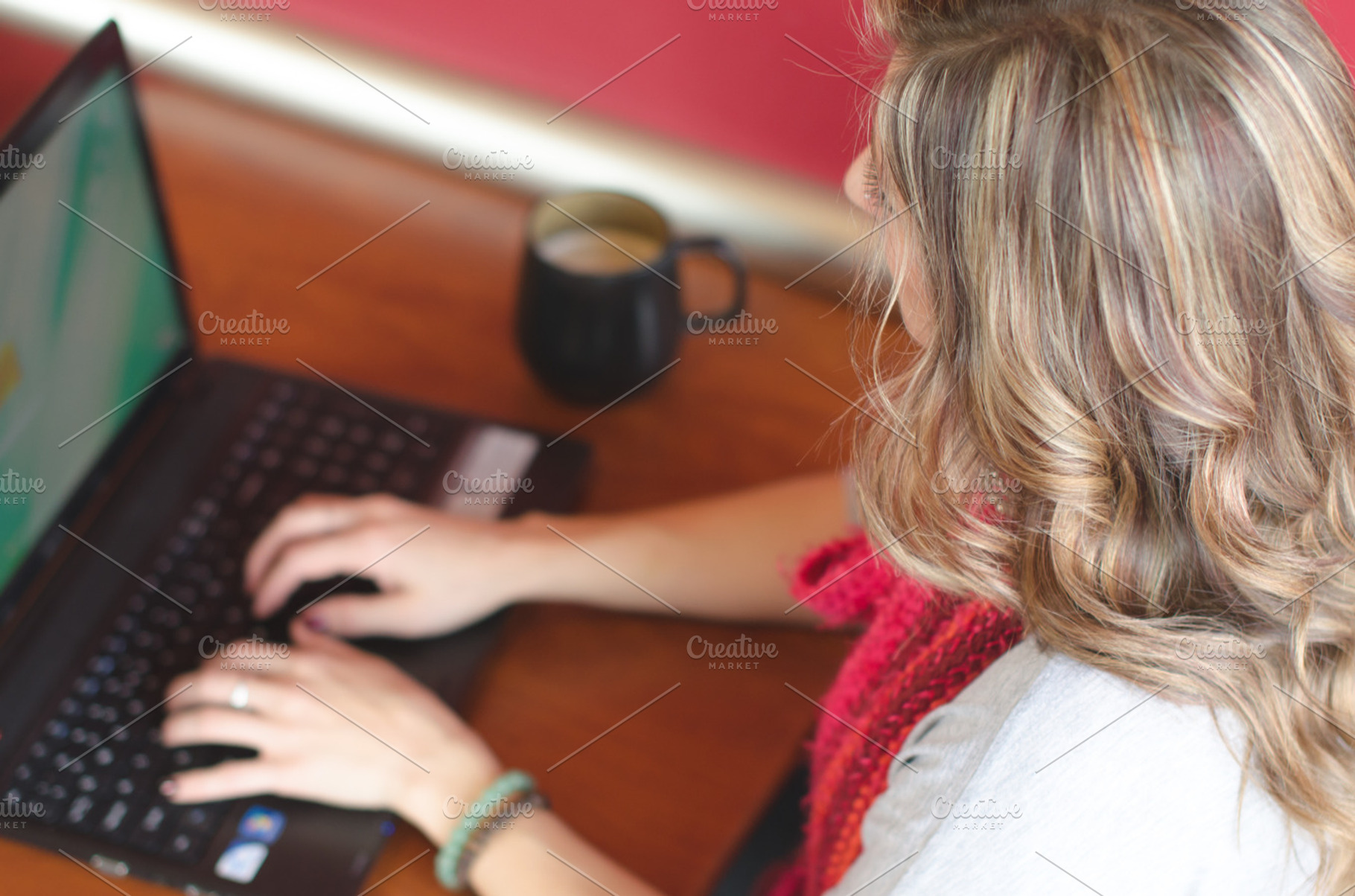 Woman using a laptop in coffee shop, a Technology Photo by Androo Interactive