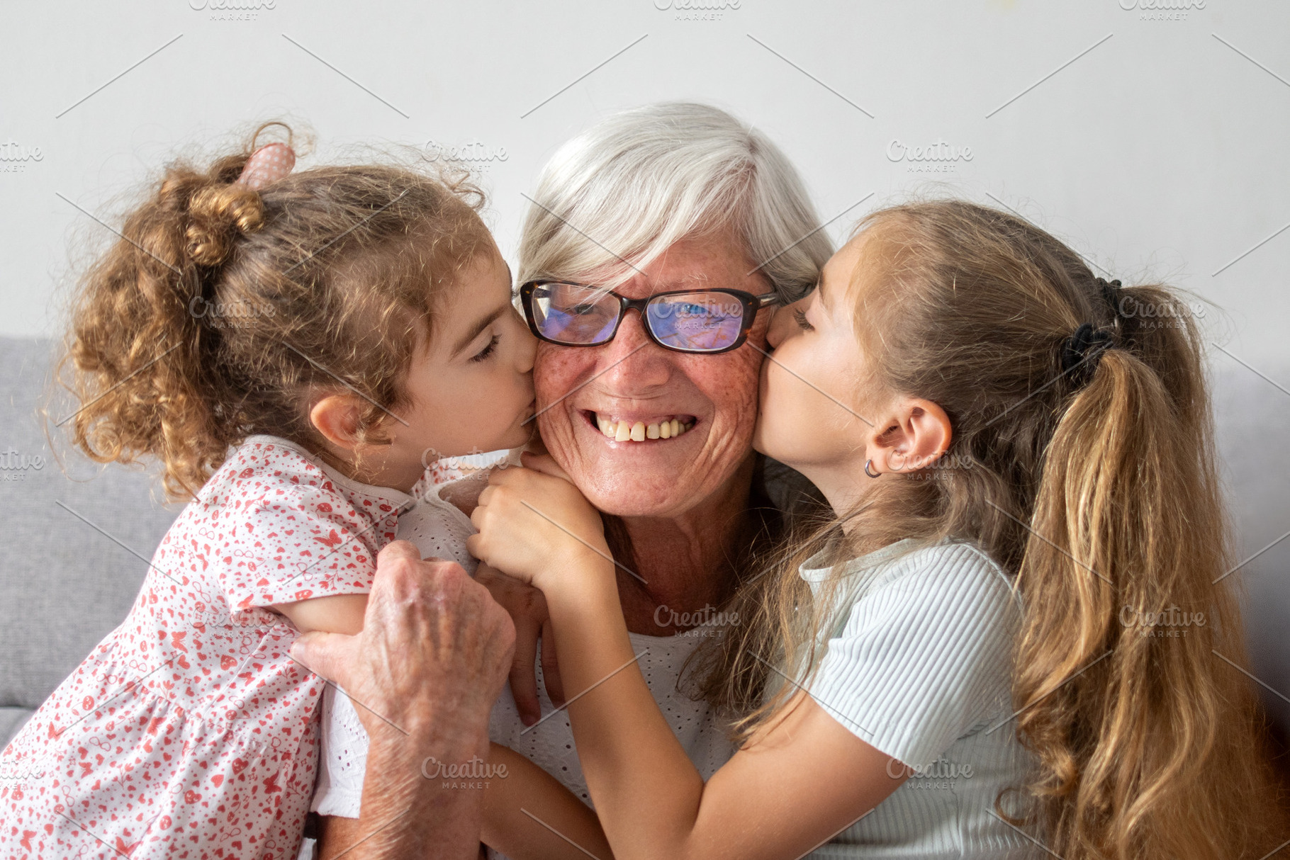 Granddaughters kissing their happy grandmother on the cheeks, a Person Photo by etorres69