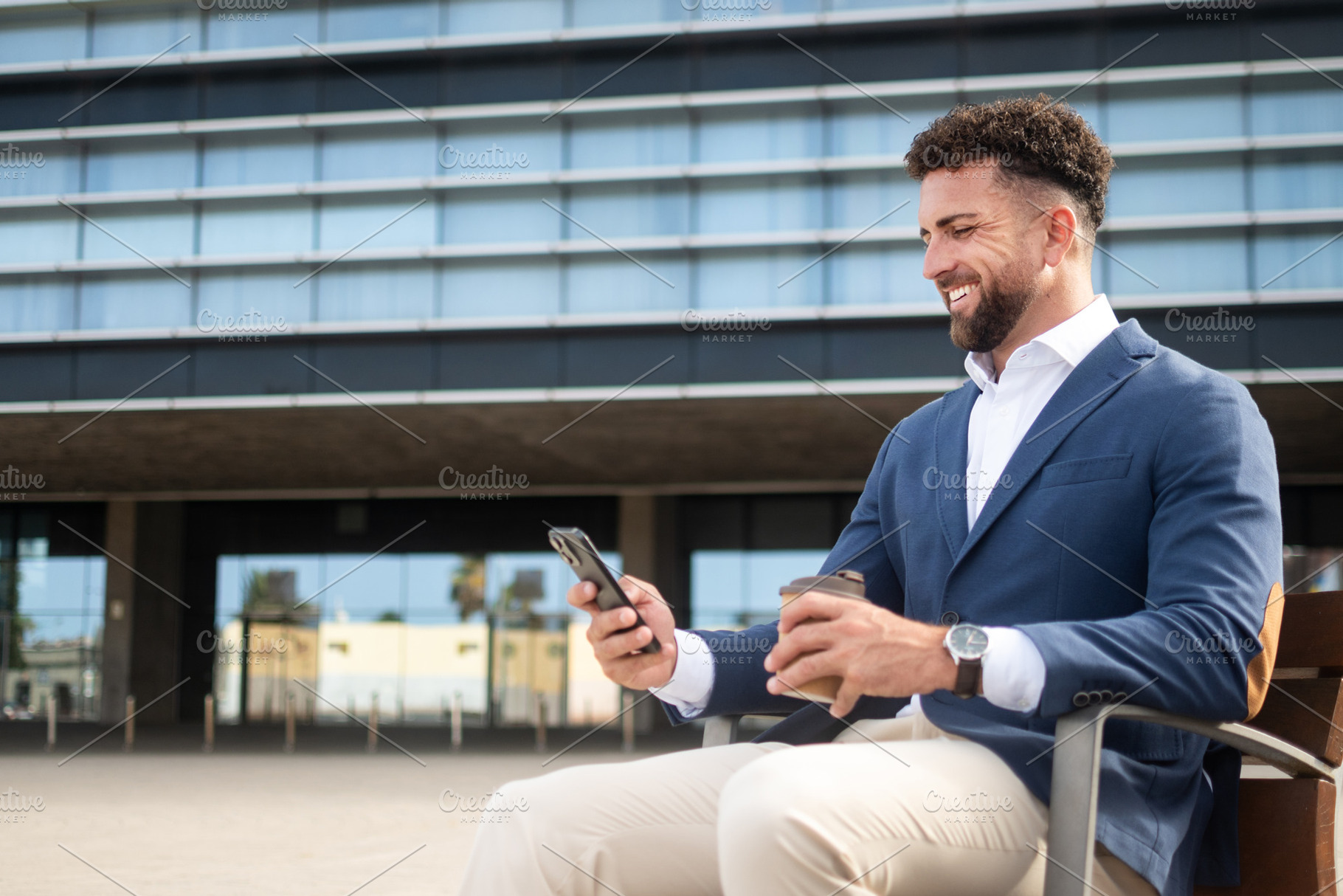 Businessman using smartphone while having coffee outside office, a Business Photo by etorres69