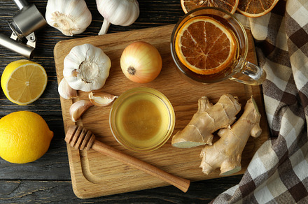 Concept of treatment colds with honey and garlic on dark backgro, a Health & Medical Photo by AtlasStudio PRO
