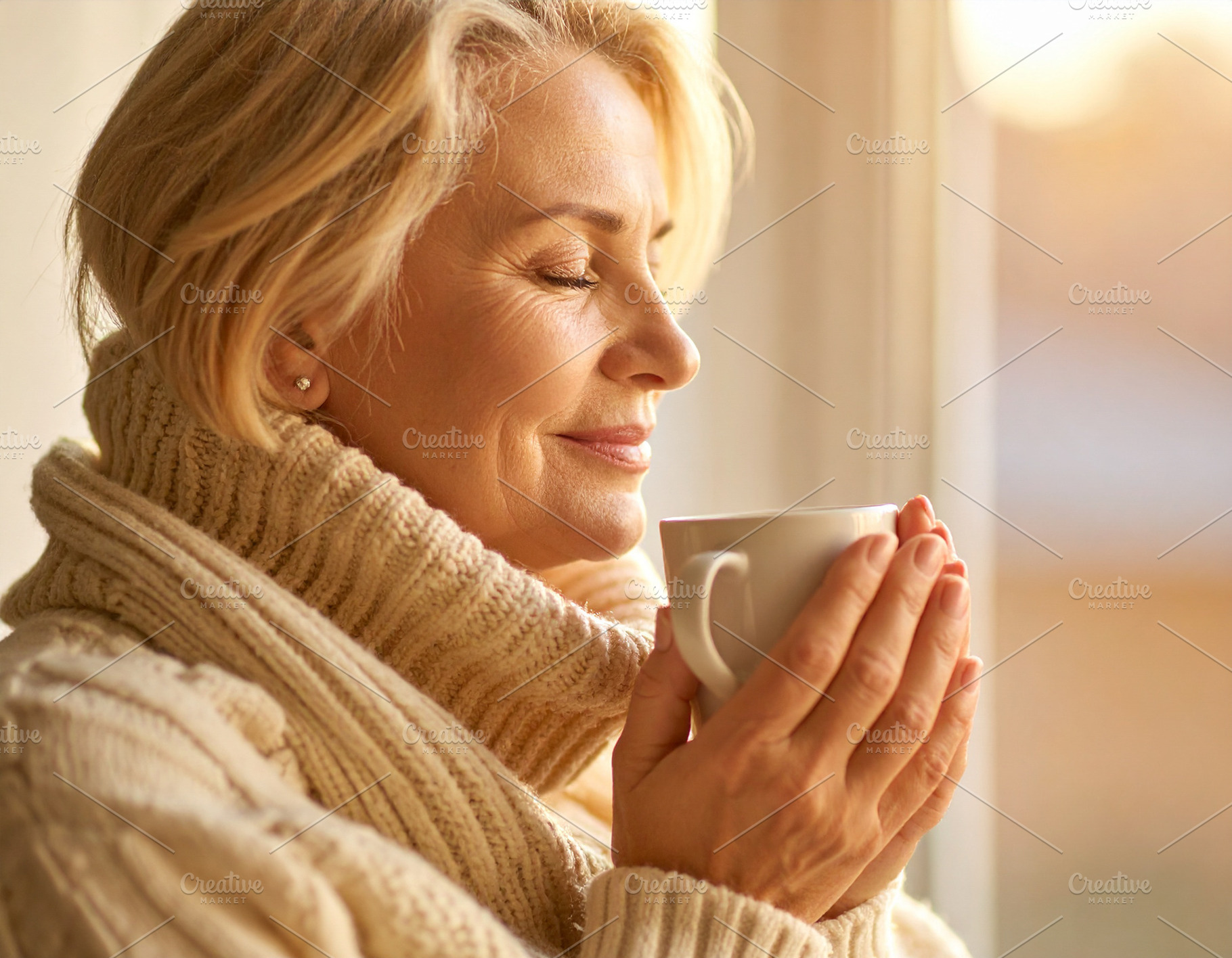Middle-aged woman with eyes closed, holding a warm cup with both, a Health & Medical Photo by DanFLCreativo
