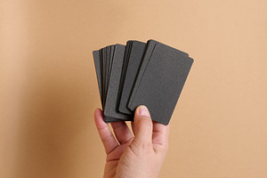 A woman's hand holds a stack of blank black paper business cards, a Business Photo by ndanko