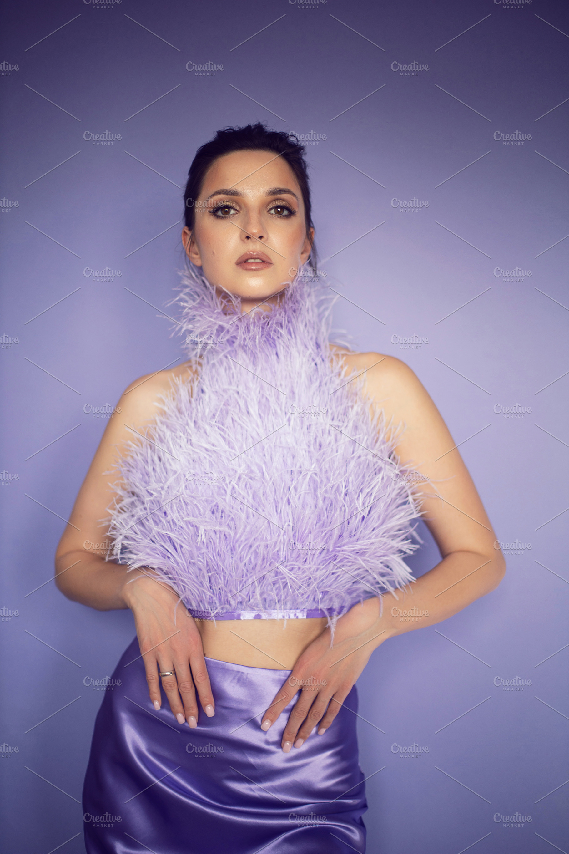 portrait woman in an evening purple dress with feathers stands in the backgroun, a Person Photo by SaulichPhoto
