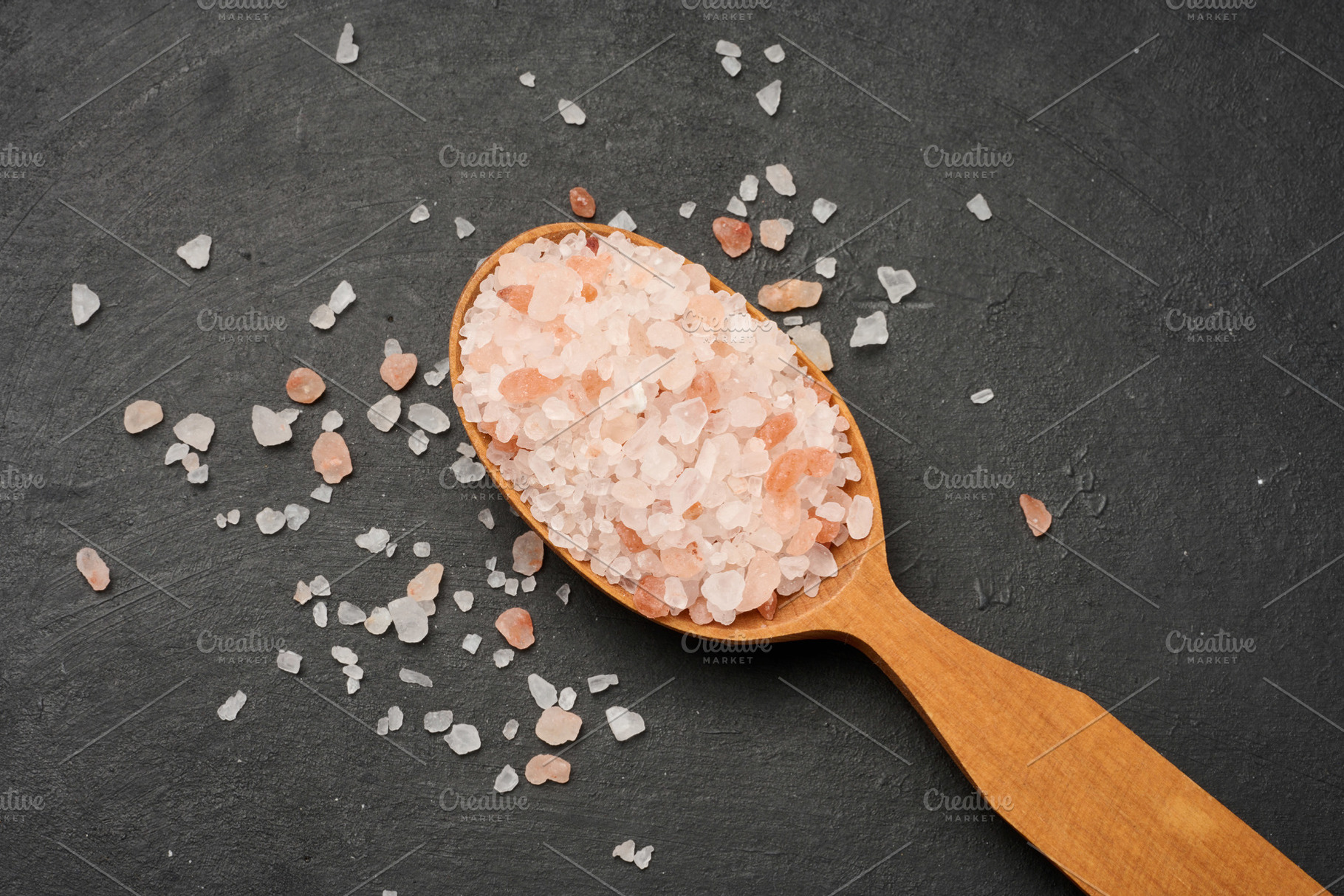 Himalayan salt crystals in a wooden spoon on a table, a Food & Drink Photo by ndanko