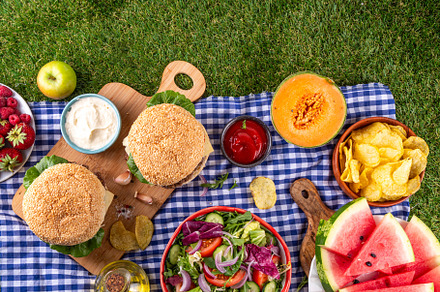 Tasty summer barbecue table with hamburgers, salads, fruits and