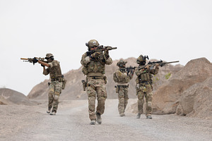 Soldiers patrol in a dessert area, a Person Photo by charnsitr