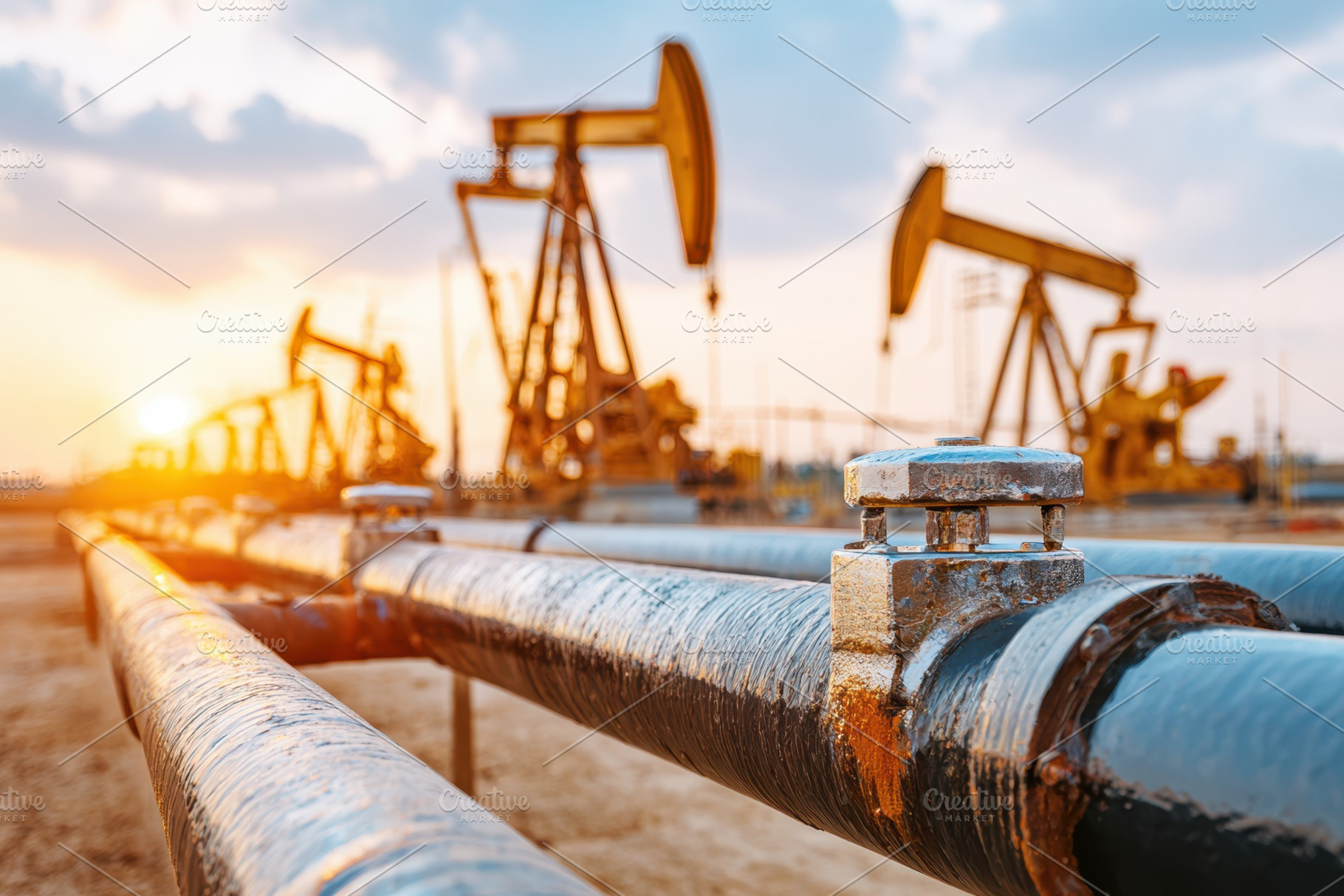 Oil pipelines and pumpjacks at sunset, an Industrial Photo by AlyaAnd