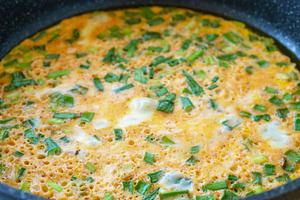 Cooking green onion omelet in frying pan, a breakfast food idea. Macro shot of, a Food & Drink Photo by Eugene_Photo