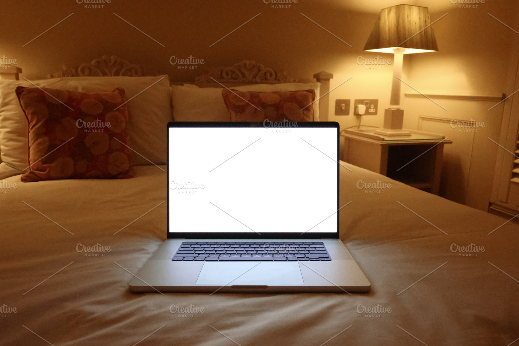 Laptop with blank screen on bed, illuminated by warm bedroom lighting at night,, a Photo by Studio ANNA