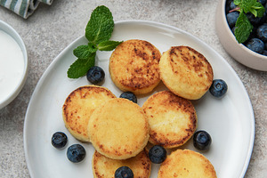 Syrniki cottage cheese pancakes with fresh blueberries and mint, a Food & Drink Photo by Olena Rudo