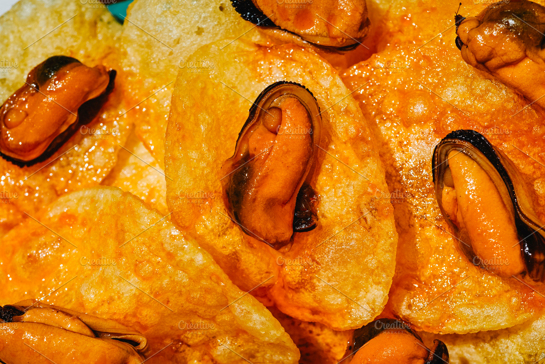 textured close-up of mussels on potato chips, a Photo by Nito