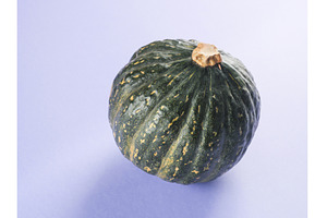 Green pumpkin on purple background