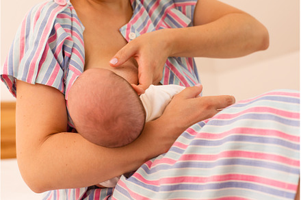 The mom is breastfeeding her newborn, a Health & Medical Photo by oksix