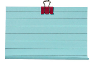 Sheet of blue lined paper secured with a red paper clip, isolate, a Business Photo by ndanko