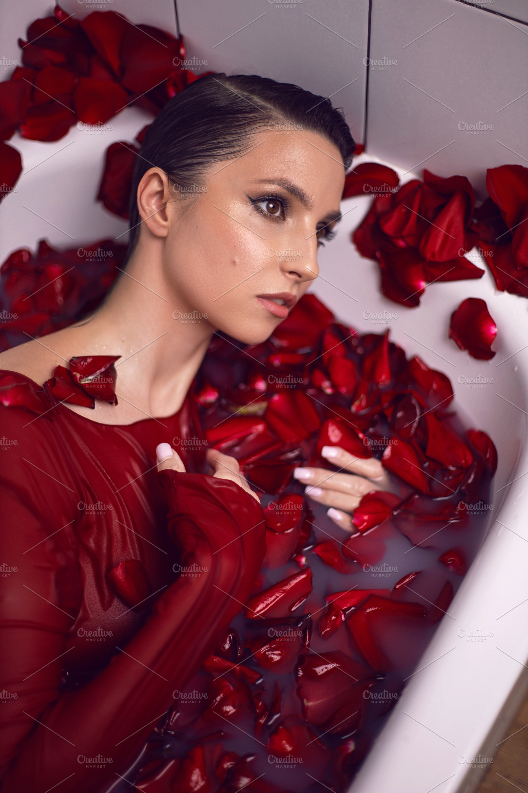 portrait of a beautiful sexy woman in a red dress lies in a white bathroom with, a Person Photo by SaulichPhoto