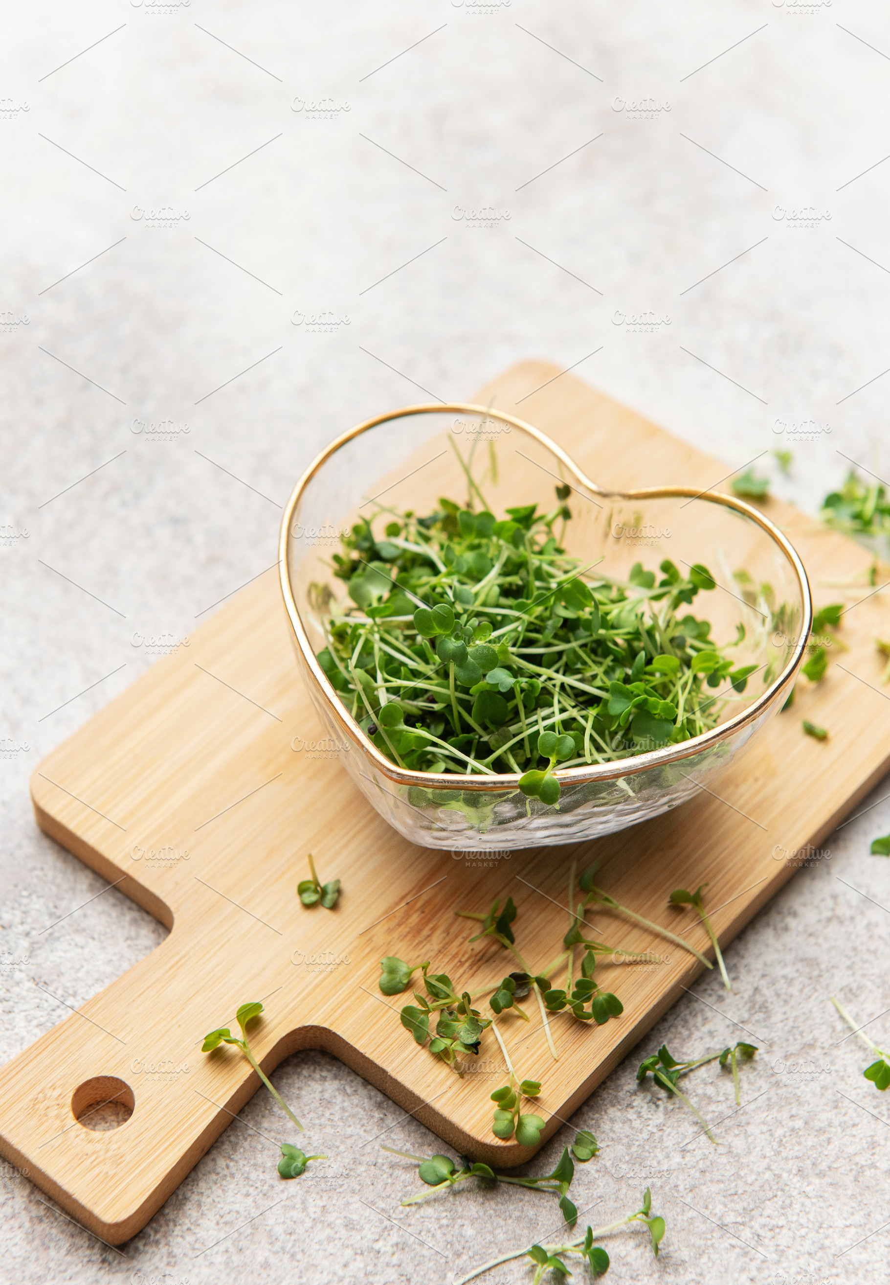 Fresh microgreens in heart bowl on wooden cutting board, a Food & Drink Photo by Olena Rudo