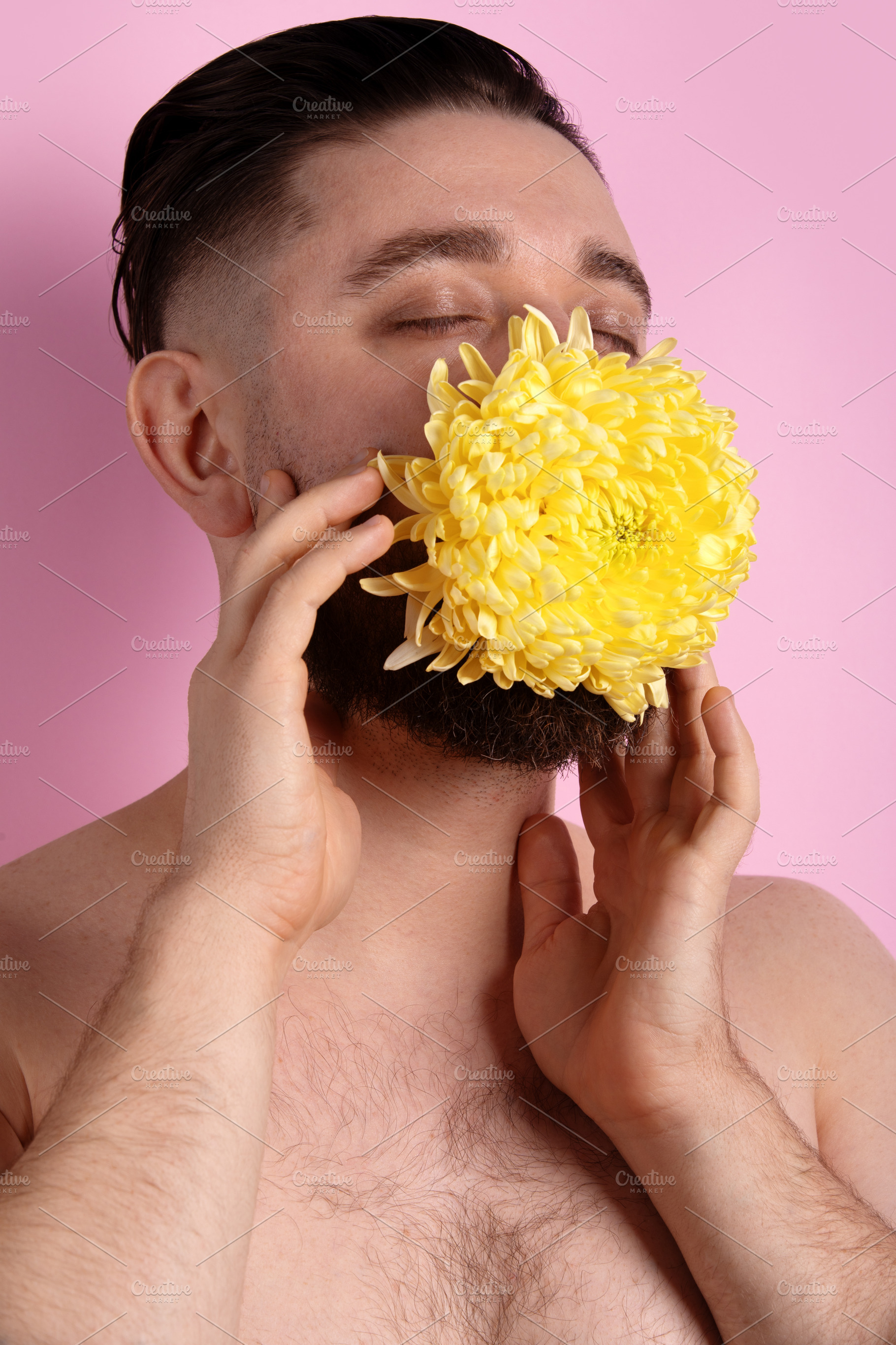 Close-up portrait of a man holding a large yellow chrysanthemum, a Person Photo by Ales Munt