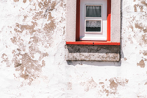 Red-trimmed window on aged wall, a Photo by SkyNext