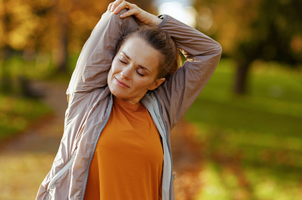 elegant woman in fitness clothes in park stretching, a Sports & Recreation Photo by Alliance Images