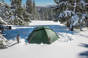 Green tent in winter forest