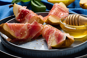 Gourmet appetizer of pear with prosciutto and sesame seeds, serv, a Food & Drink Photo by ndanko