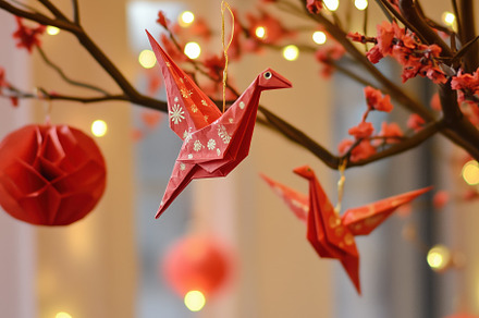 Decorative red origami cranes hanging from a branch adorned with pink blossoms, an Arts & Entertainment Photo by Textures & Backgrounds