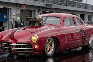 Vintage red drag racing car with exposed blower engine ready at, a Photo by AS photostudio