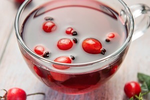 Rosehip tea brewing in glass cup on rustic wooden table, a Food & Drink Photo by Olena Rudo