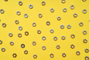 Metal nuts pattern on yellow